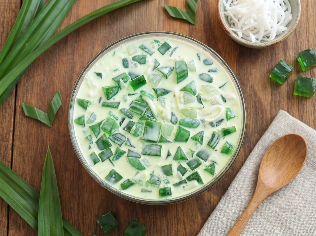 Glass bowls of buko pandan: green pandan jelly, young coconut strips, nata de coco, and pale cream