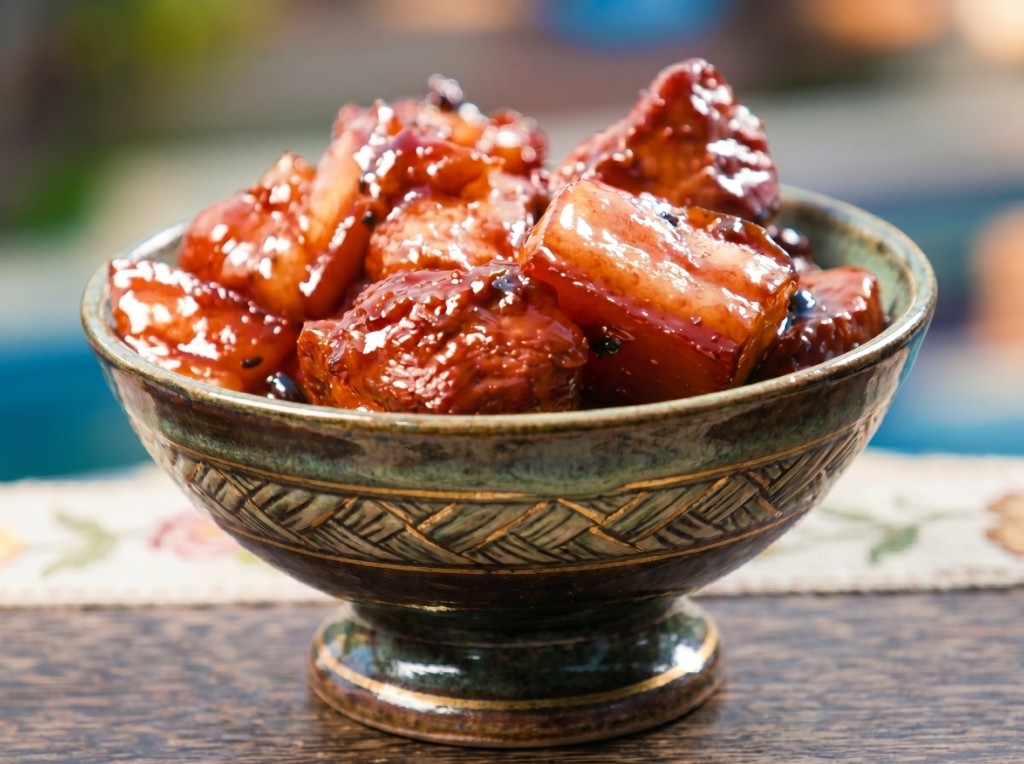 Estofadong Batangas in a teal ceramic bowl: large pork belly cubes glazed in thick dark glossy sauce with tausi and pepper, piled high with rendered fat glistening