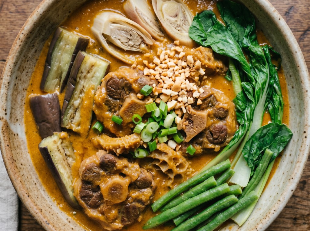 Filipino kare-kare with oxtail, tripe, kalabasa, and annatto-orange peanut sauce