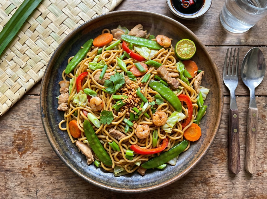Filipino pancit canton with shrimp, pork, chicken, snow peas, and fried garlic
